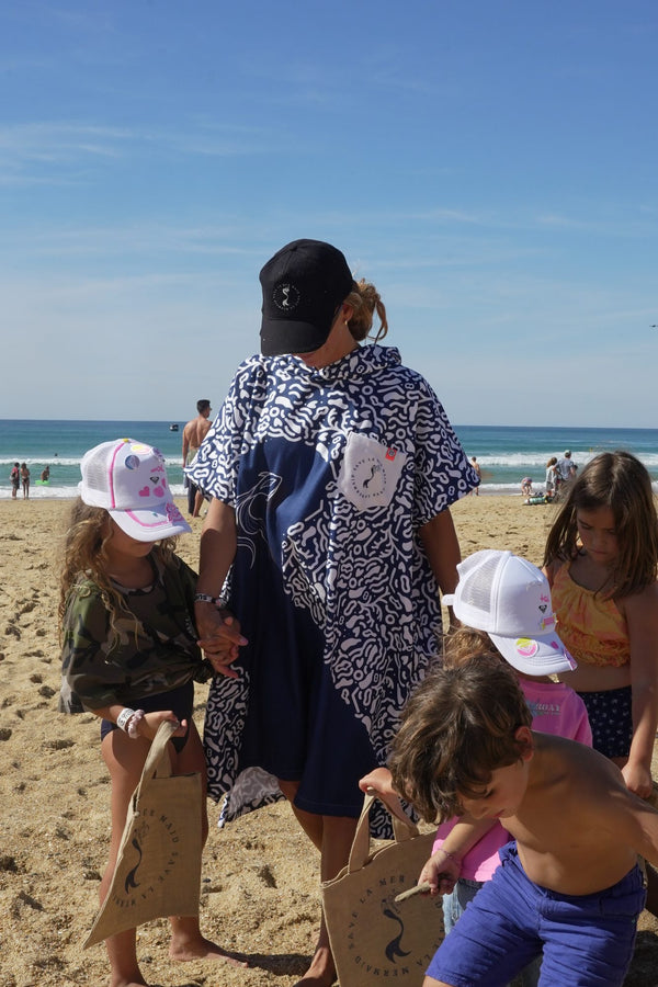 Poncho Save La Mermaid porte sur la plage sous un ciel bleu